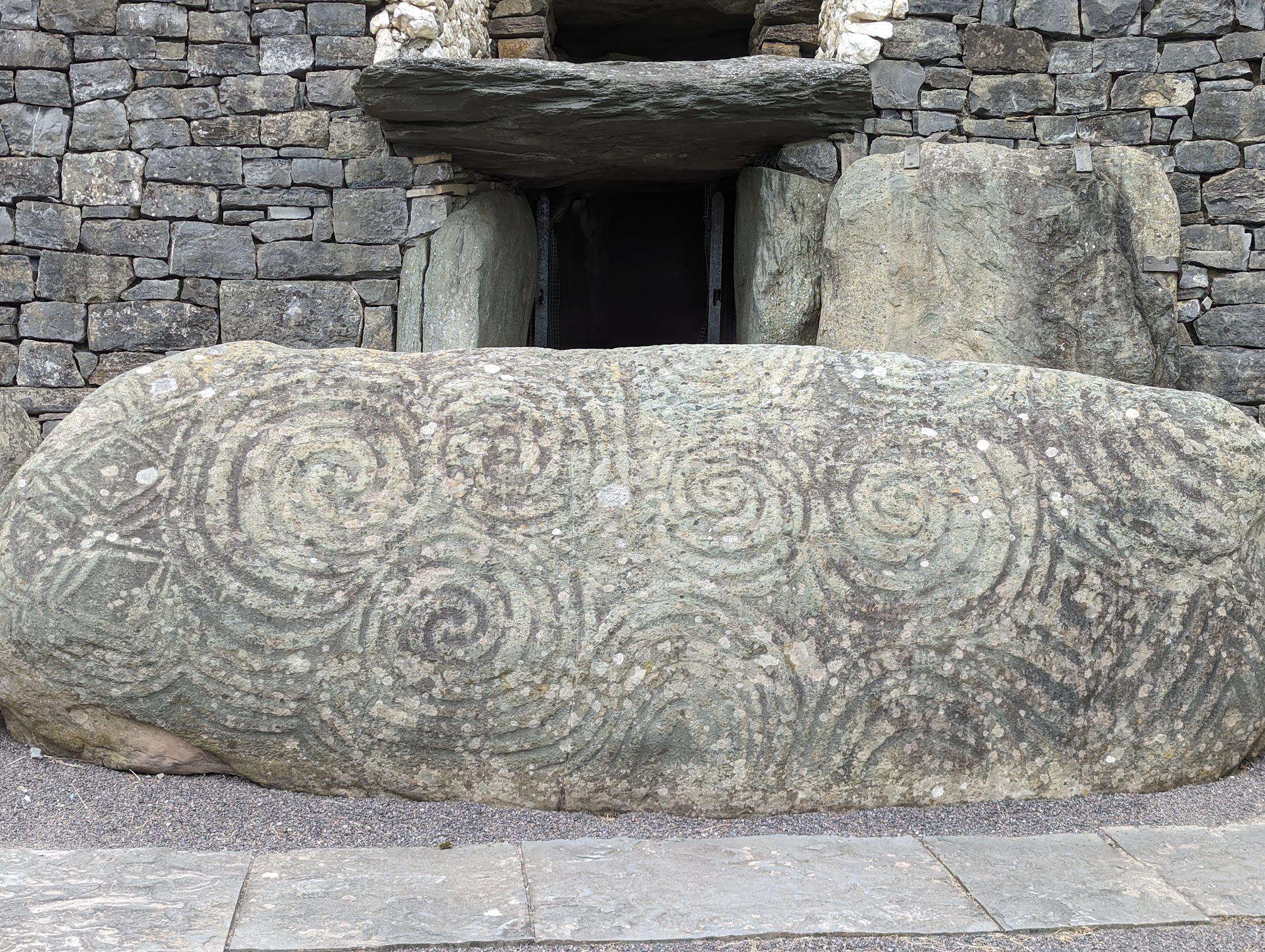 The magnificent triskelion (triple spiral) design on the famous Entrance Stone in front of the door to the Newgrange passage tomb in Ireland.